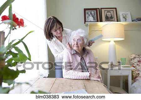 Woman combing hair of elderly mother View Large Photo Image Stock Image - Woman combing hair of elderly mother. Fotosearch