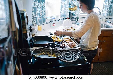Woman cooking breakfast in kitchen View Large Photo Image Stock Photograph - Woman cooking breakfast in kitchen. Fotosearch