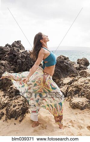 Woman dancing on rocky beach View Large Photo Image Stock Image - Woman dancing on rocky beach. Fotosearch