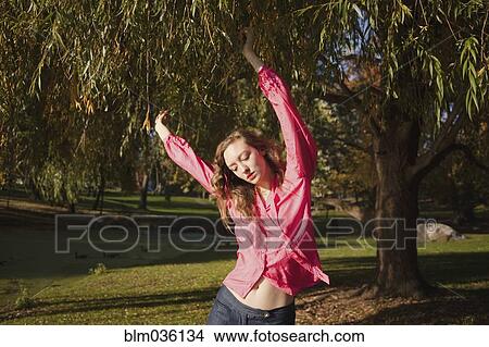 Woman dancing under tree in park View Large Photo Image Picture - Woman dancing under tree in park. Fotosearch