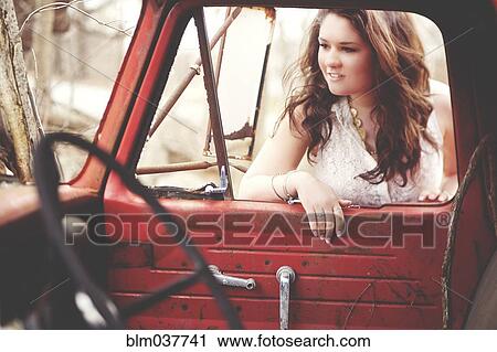 Stock Image - Woman examining vintage truck interior. Fotosearch