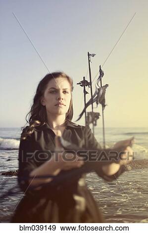 Stock Photo - Woman holding model ship on beach. Fotosearch