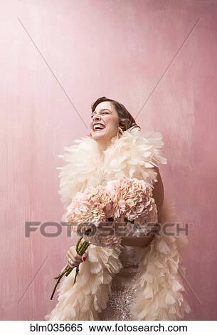 Woman in feather boa holding bouquet of flowers View Large Photo Image Stock Photography - Woman in feather boa holding bouquet of flowers. Fotosearch