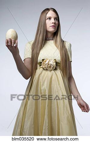 Woman in gown holding egg View Large Photo Image Stock Image - Woman in gown holding egg. Fotosearch