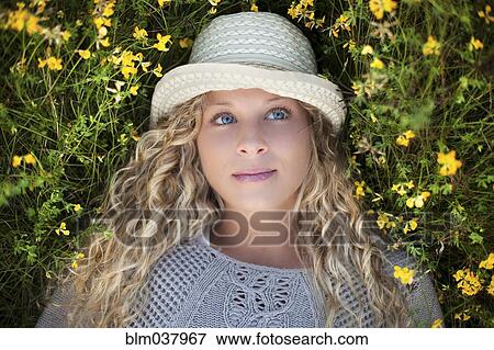 Woman in straw hat laying in flowers View Large Photo Image Stock Photo - Woman in straw hat laying in flowers. Fotosearch