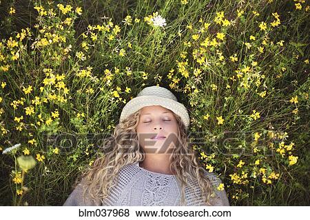 Woman in straw hat laying in flowers View Large Photo Image Stock Photo - Woman in straw hat laying in flowers. Fotosearch