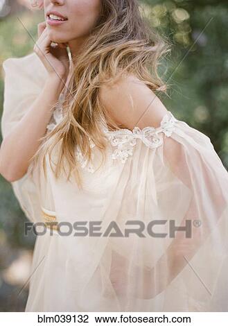 Woman in white dress standing in garden View Large Photo Image Stock Image - Woman in white dress standing in garden. Fotosearch