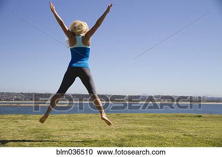 Woman jumping for joy in field View Large Photo Image Stock Image - Woman jumping for joy in field. Fotosearch