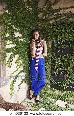 Woman leaning on ivy wall View Large Photo Image Stock Image - Woman leaning on ivy wall. Fotosearch
