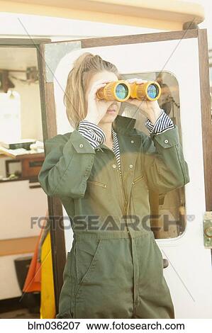 Woman looking through binoculars on boat deck View Large Photo Image Stock Photo - Woman looking through binoculars on boat deck. Fotosearch