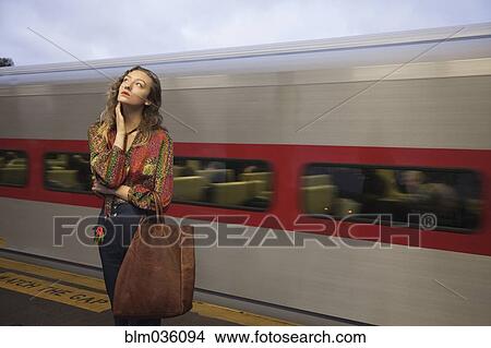 Woman missing passing train in train station View Large Photo Image Picture - Woman missing passing train in train station. Fotosearch