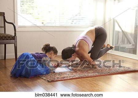 Woman practicing yoga and helping daughter with homework View Large Photo Image Stock Image - Woman practicing yoga and helping daughter with homework. Fotosearch