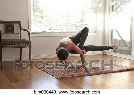 Woman practicing yoga in studio View Large Photo Image Stock Image - Woman practicing yoga in studio. Fotosearch