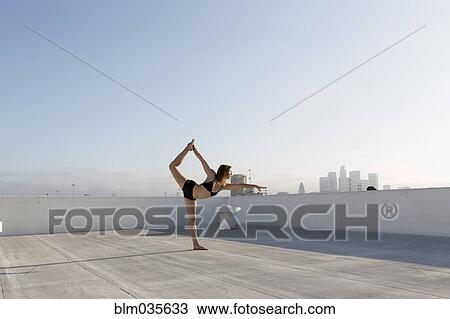 Woman practicing yoga on urban rooftop View Large Photo Image Stock Image - Woman practicing yoga on urban rooftop. Fotosearch