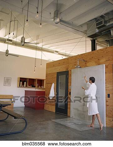 Woman preparing open shower in modern living space View Large Photo Image Stock Photo - Woman preparing open shower in modern living space. Fotosearch