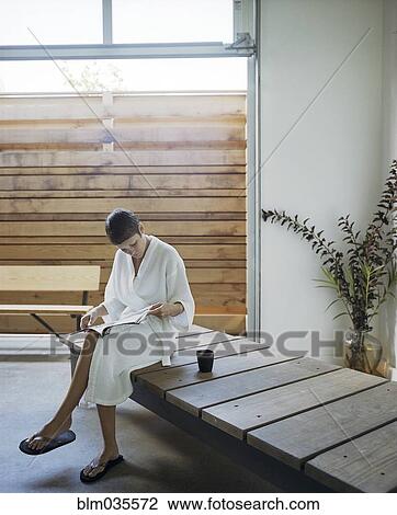 Stock Image - Woman reading magazine in spa. Fotosearch