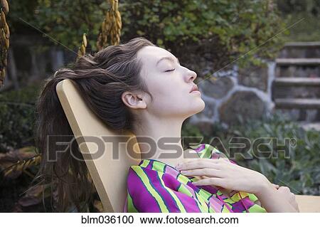 Woman relaxing in lawn chair in backyard View Large Photo Image Stock Image - Woman relaxing in lawn chair in backyard. Fotosearch