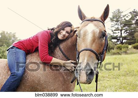Woman riding horse in rural field View Large Photo Image Stock Photo - Woman riding horse in rural field. Fotosearch
