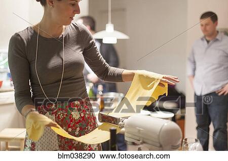 Woman rolling sheets of pasta in kitchen View Large Photo Image Stock Image - Woman rolling sheets of pasta in kitchen. Fotosearch