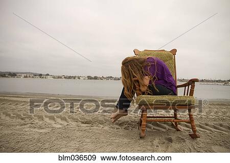 Woman sitting in armchair on beach View Large Photo Image Stock Photo - Woman sitting in armchair on beach. Fotosearch