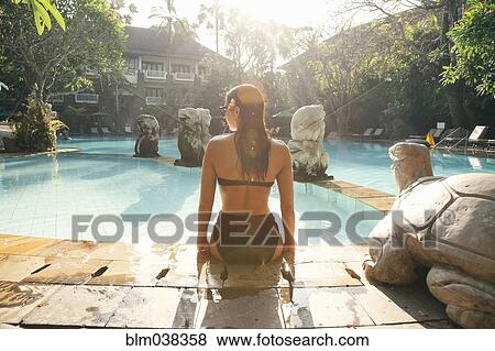 Stock Photo - Woman sitting in swimming pool. Fotosearch