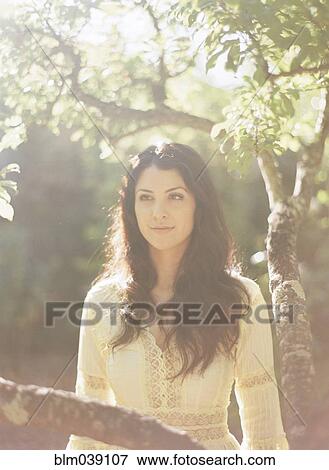Woman sitting in tree View Large Photo Image Stock Photo - Woman sitting in tree. Fotosearch