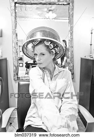Woman sitting under hair dryer in salon View Large Photo Image Stock Photo - Woman sitting under hair dryer in salon. Fotosearch