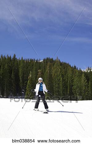 Picture - Woman skiing on snowy slope. Fotosearch