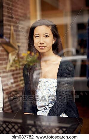 Woman smiling behind window in cafe View Large Photo Image Stock Image - Woman smiling behind window in cafe. Fotosearch