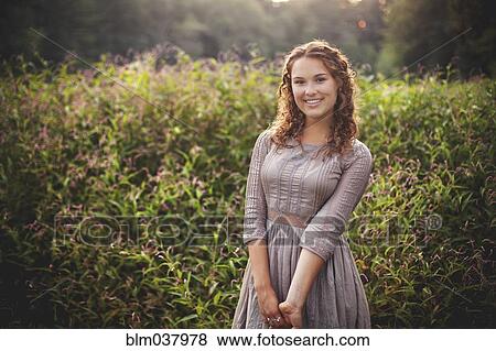 Stock Photo - Woman smiling in rural field. Fotosearch