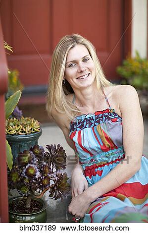 Stock Photo - Woman smiling on front stoop. Fotosearch