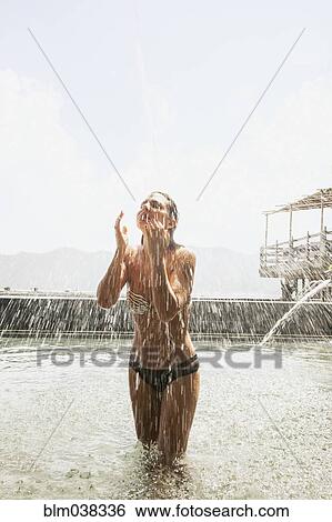 Stock Photograph - Woman splashing in pool outdoors. Fotosearch