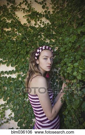 Woman standing at ivy wall View Large Photo Image Stock Photograph - Woman standing at ivy wall. Fotosearch