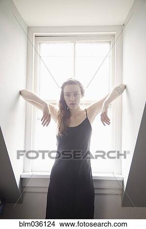Woman standing at sunny window View Large Photo Image Picture - Woman standing at sunny window. Fotosearch