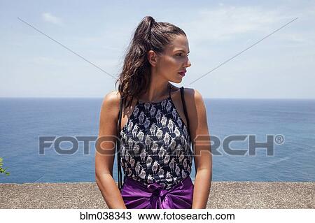 Woman standing by wall overlooking seascape View Large Photo Image Stock Image - Woman standing by wall overlooking seascape. Fotosearch