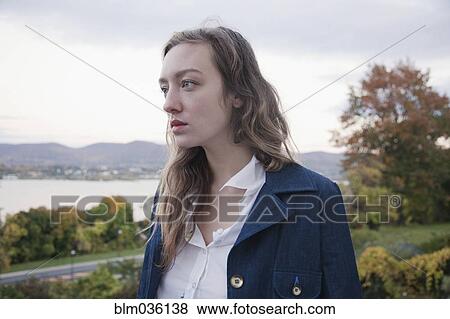 Woman standing in park near lake View Large Photo Image Stock Photo - Woman standing in park near lake. Fotosearch