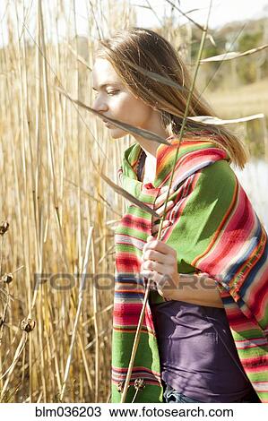 Woman standing in tall plants in marsh View Large Photo Image Stock Image - Woman standing in tall plants in marsh. Fotosearch