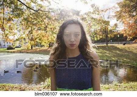 Woman standing near duck pond in park View Large Photo Image Stock Photo - Woman standing near duck pond in park. Fotosearch