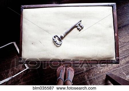 Woman standing near skeleton key on table View Large Photo Image Stock Photo - Woman standing near skeleton key on table. Fotosearch