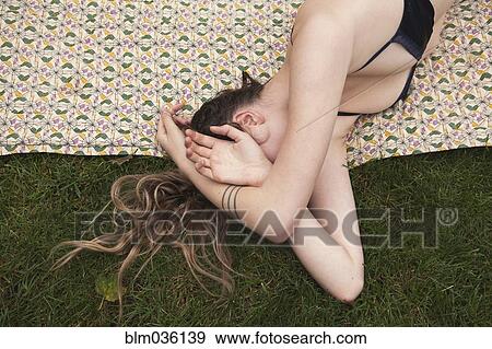 Woman sunbathing in bikini on blanket in grass View Large Photo Image Stock Photo - Woman sunbathing in bikini on blanket in grass. Fotosearch