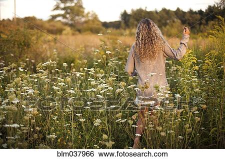 Woman walking in rural field View Large Photo Image Stock Photograph - Woman walking in rural field. Fotosearch