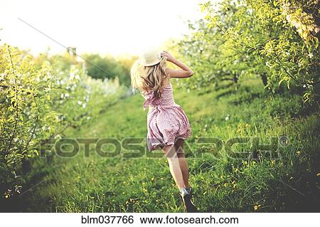 Woman walking in rural orchard View Large Photo Image Stock Photograph - Woman walking in rural orchard. Fotosearch