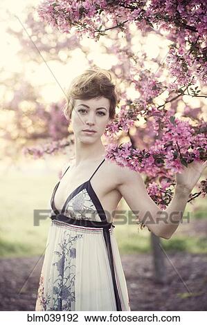 Woman walking under flowering trees in garden View Large Photo Image Stock Image - Woman walking under flowering trees in garden. Fotosearch