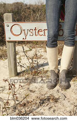 Woman wearing boots near sign on beach View Large Photo Image Picture - Woman wearing boots near sign on beach. Fotosearch