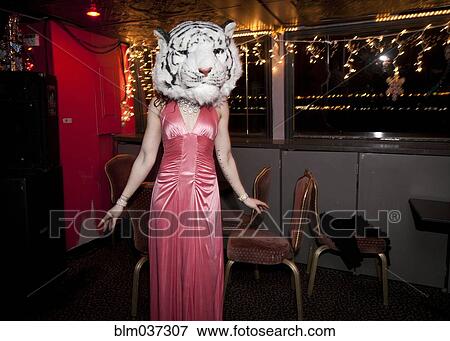 Stock Photo - Woman wearing evening gown and tiger mask in bar. Fotosearch