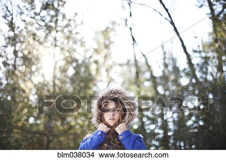 Picture - Woman wearing fur hood under trees. Fotosearch