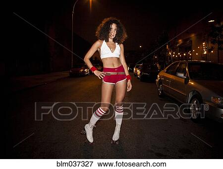 Stock Photo - Woman wearing roller skating costume at night. Fotosearch