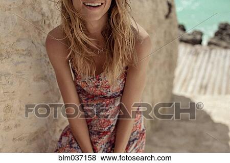 Stock Photo - Woman wearing sun dress on steps. Fotosearch