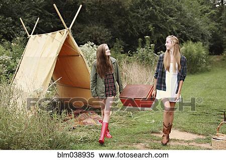 Women carrying vintage cooler near camping tent in forest View Large Photo Image Stock Photography - Women carrying vintage cooler near camping tent in forest. Fotosearch