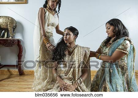 Women dressing bride in traditional dresses and jewelry View Large Photo Image Stock Photograph - Women dressing bride in traditional dresses and jewelry. Fotosearch